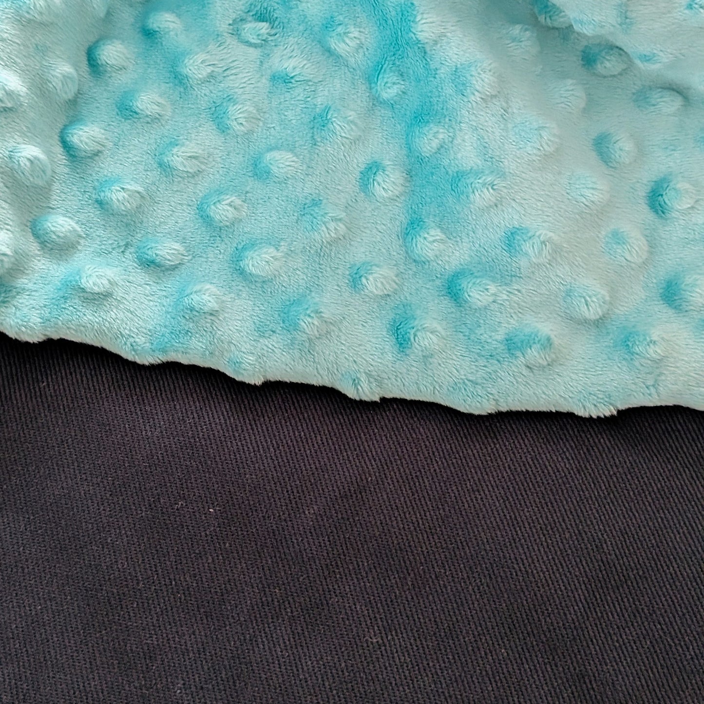 Close-up of a textured blue fabric with a dark background