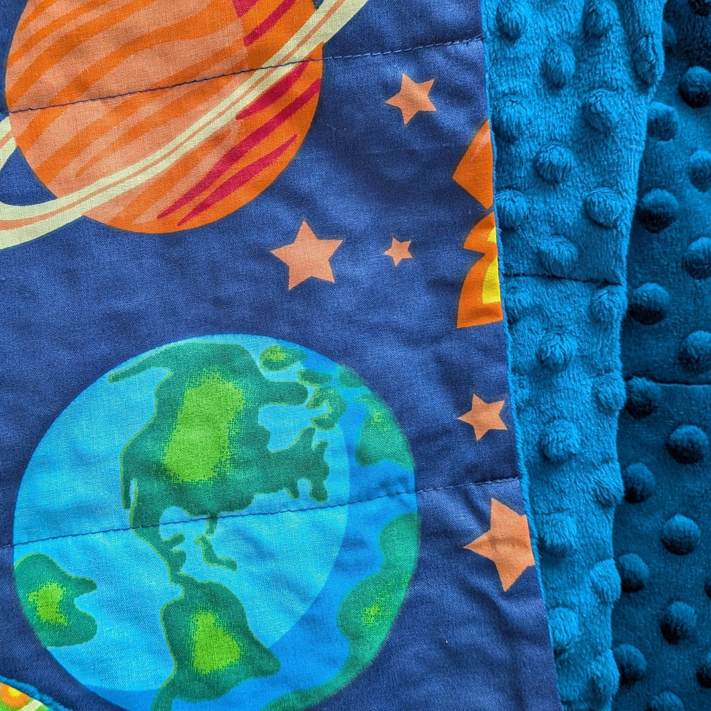 Folded weighted blanket with galaxy-themed design