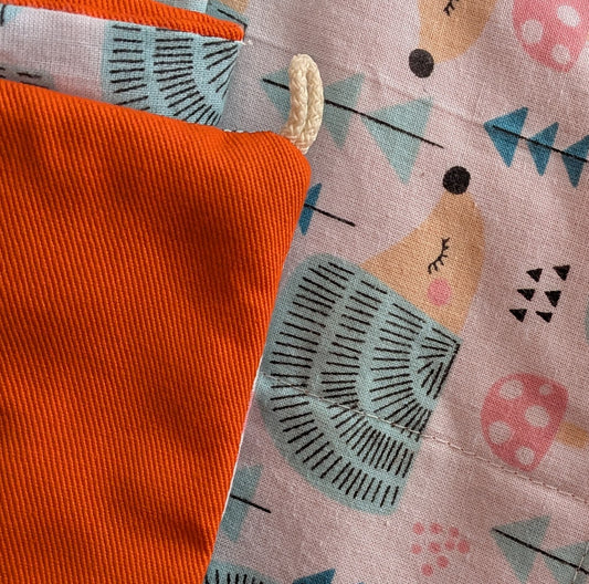 Close-up of fabric with hedgehog pattern and orange material