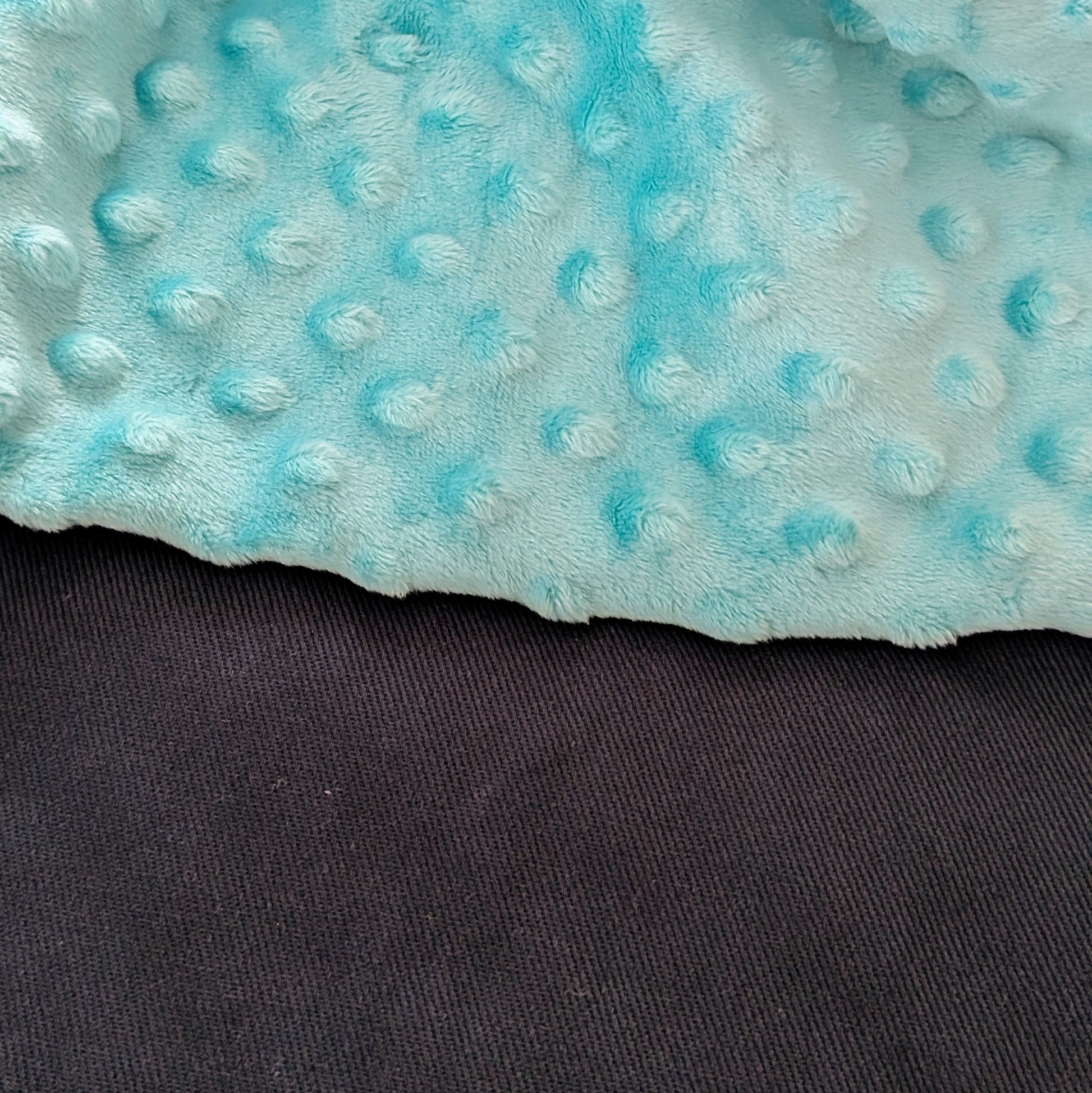 Close-up of a textured blue fabric with a dark background