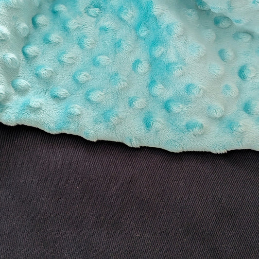 Close-up of a textured blue fabric with a dark background
