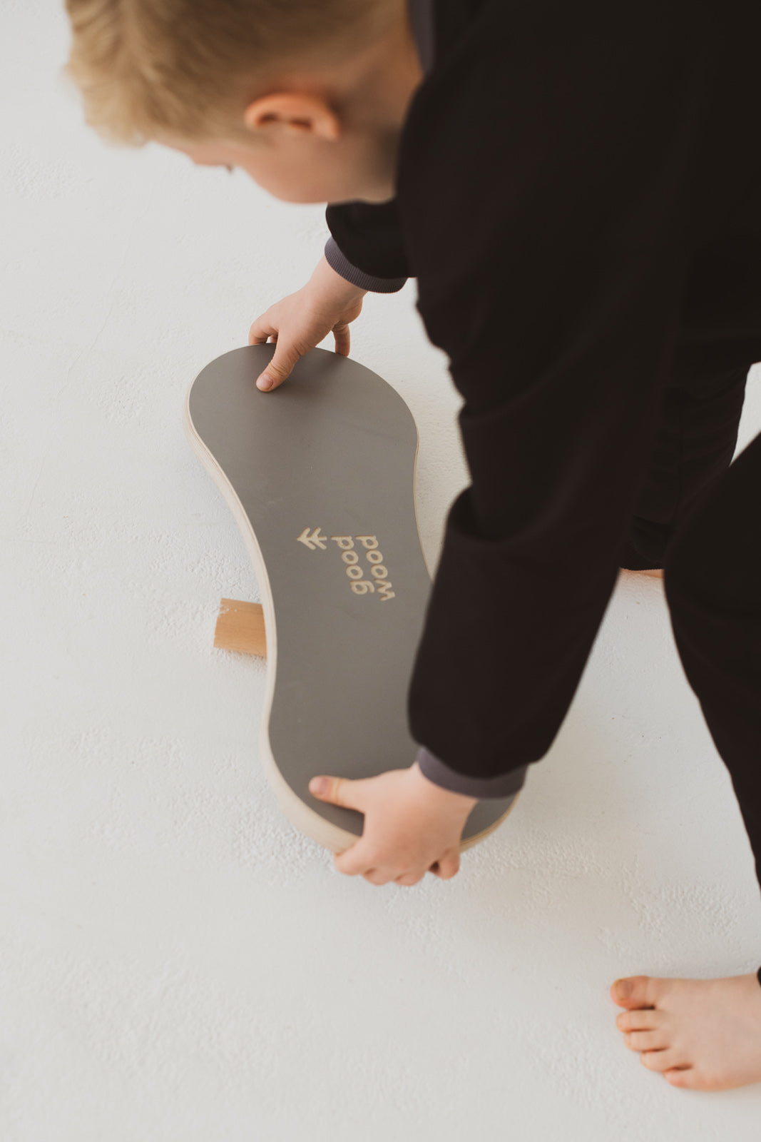 A BOY BALANCING ON THE GREY BALANCE BOARD / TRICK BOARD FOR KIDS- GOOD WOOD