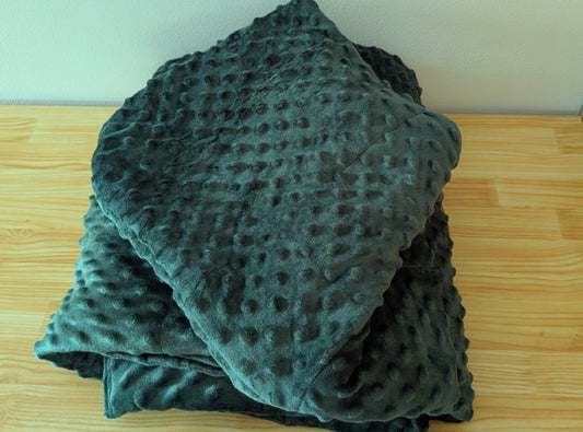 bottle green weighted hoodie on a wooden surface